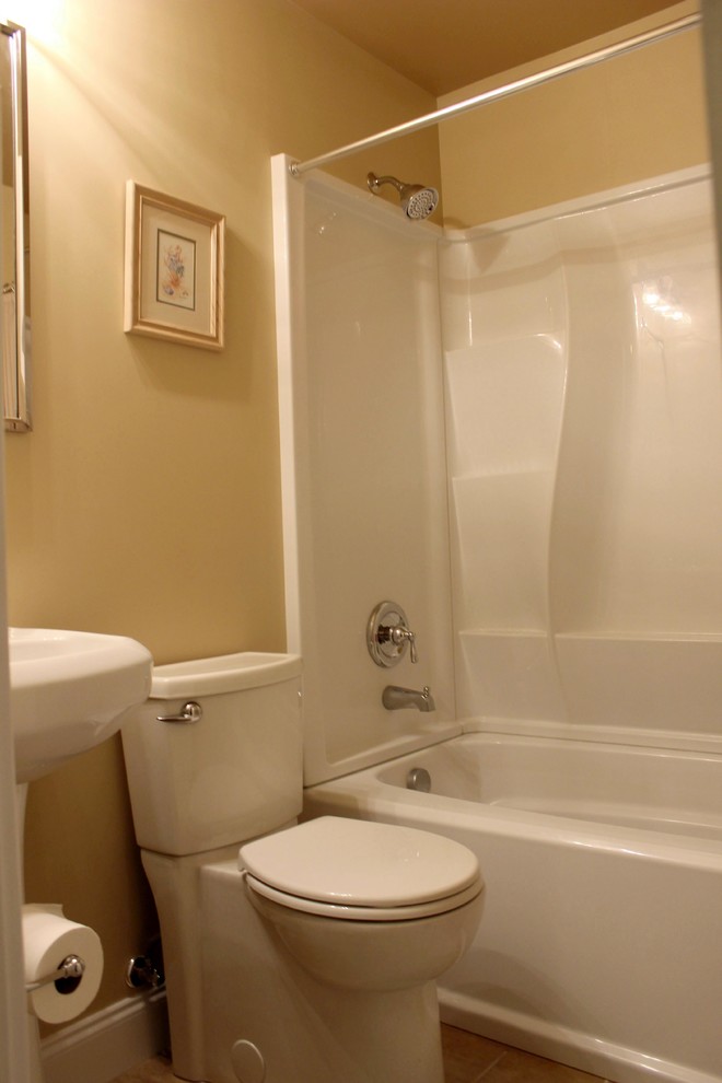 Exempel på ett litet klassiskt en-suite badrum, med ett piedestal handfat, ett badkar i en alkov, en dusch/badkar-kombination, en toalettstol med hel cisternkåpa, brun kakel, keramikplattor, orange väggar och klinkergolv i keramik