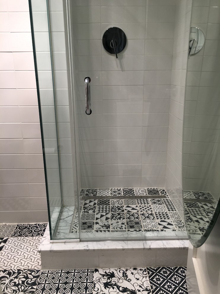 Inspiration for a small modern 3/4 white tile and ceramic tile cement tile floor and multicolored floor alcove shower remodel in New York with flat-panel cabinets, black cabinets, a one-piece toilet, gray walls, a console sink and a hinged shower door
