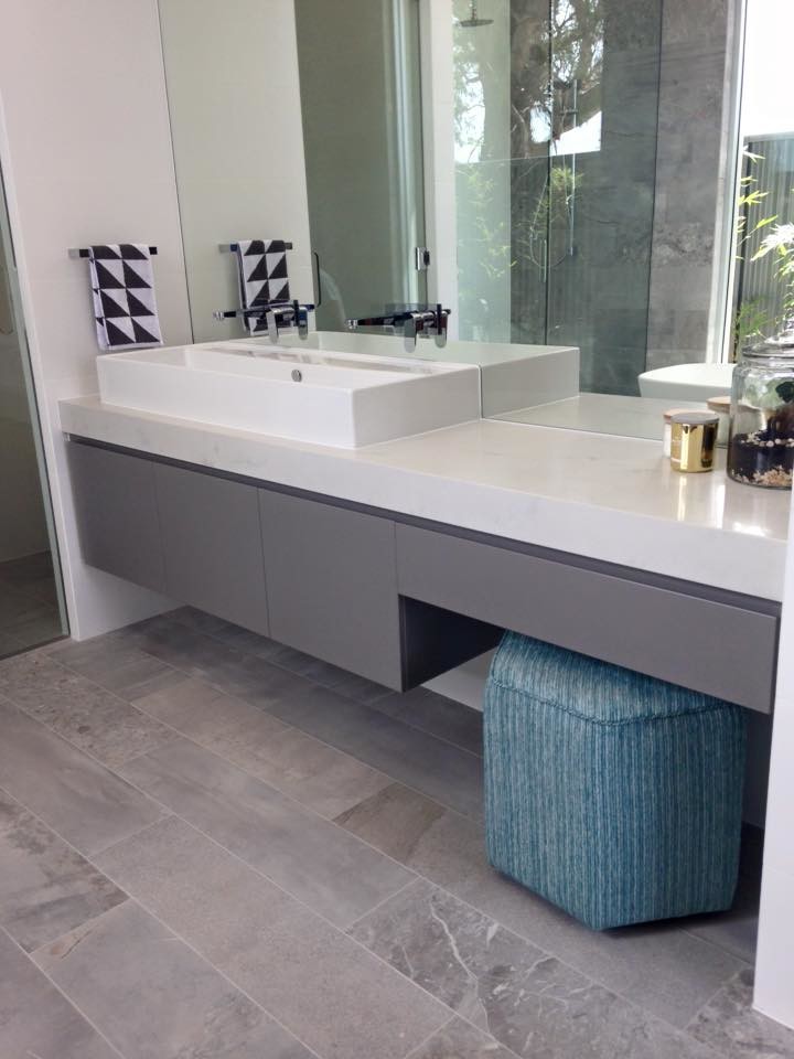 Idée de décoration pour une salle d'eau minimaliste de taille moyenne avec une baignoire indépendante, un carrelage gris, des carreaux de porcelaine, un mur gris et un sol en carrelage de porcelaine.