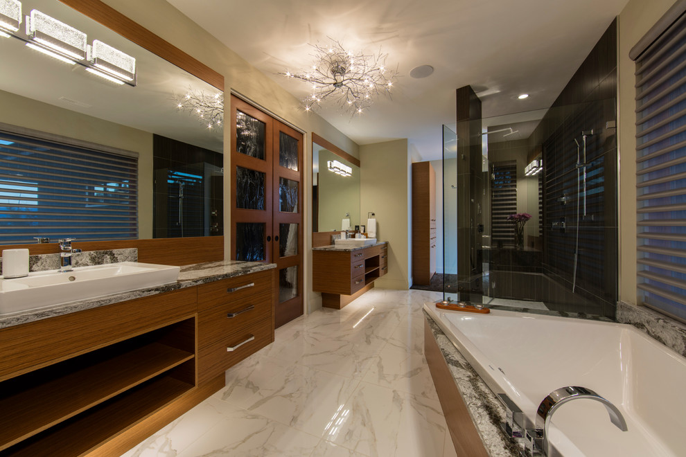 This is an example of a large contemporary ensuite bathroom in Vancouver with flat-panel cabinets, medium wood cabinets, a built-in bath, a walk-in shower, white tiles, stone tiles, marble flooring, marble worktops, brown walls, a vessel sink, white floors and a hinged door.