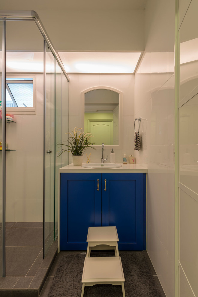 Aménagement d'une salle d'eau classique avec un placard à porte shaker, des portes de placard bleues, une douche d'angle, un carrelage blanc, des carreaux de porcelaine, un sol en carrelage de porcelaine, un lavabo posé et un plan de toilette en quartz modifié.