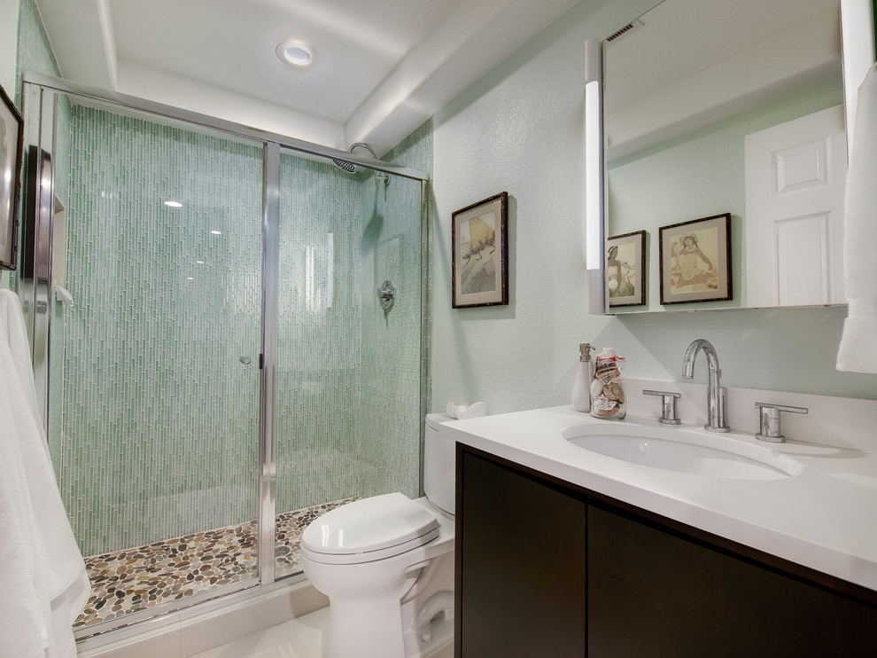 Пример оригинального дизайна: ванная комната среднего размера в современном стиле с врезной раковиной, плоскими фасадами, темными деревянными фасадами, душем в нише, раздельным унитазом, зеленой плиткой, удлиненной плиткой, столешницей из искусственного кварца, зелеными стенами, полом из галечной плитки и душевой кабиной