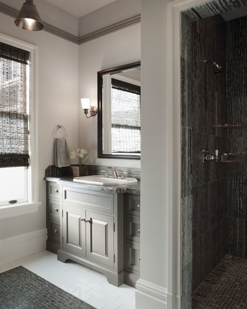 Réalisation d'une douche en alcôve tradition avec un lavabo posé, un placard avec porte à panneau encastré, des portes de placard grises, un carrelage gris et un mur gris.