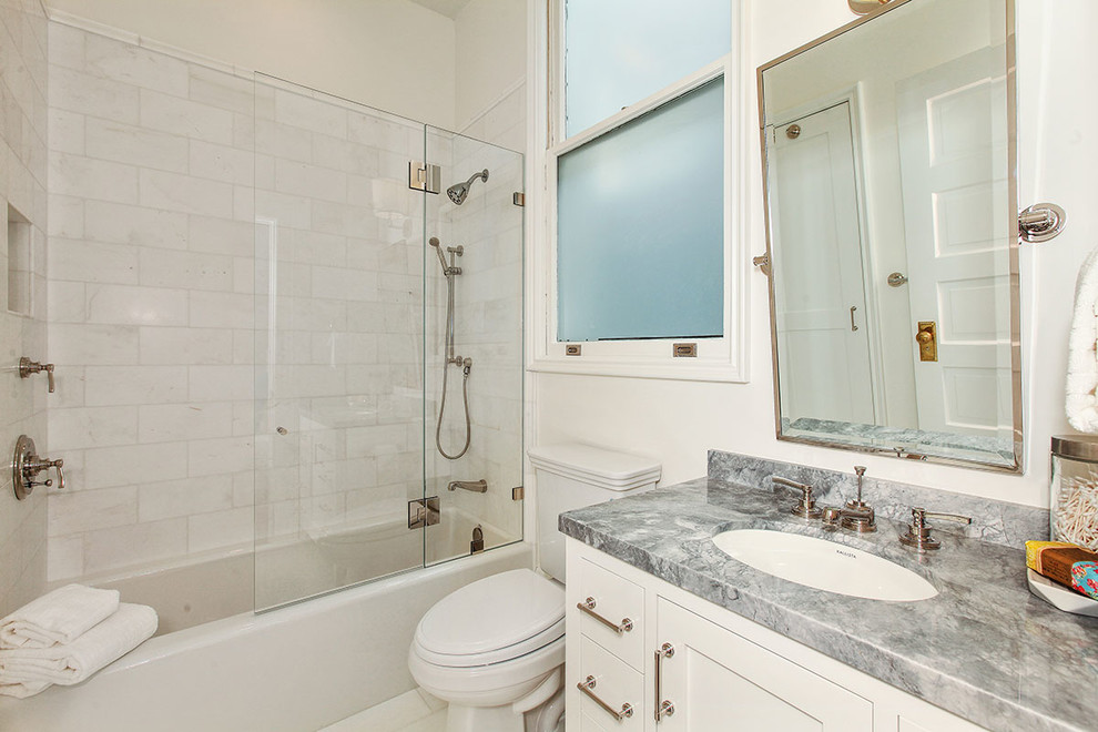 Expansive traditional family bathroom in San Francisco with recessed-panel cabinets, white cabinets, a built-in bath, a walk-in shower, a two-piece toilet, white tiles, stone tiles, white walls, porcelain flooring, a submerged sink, marble worktops, white floors and a hinged door.