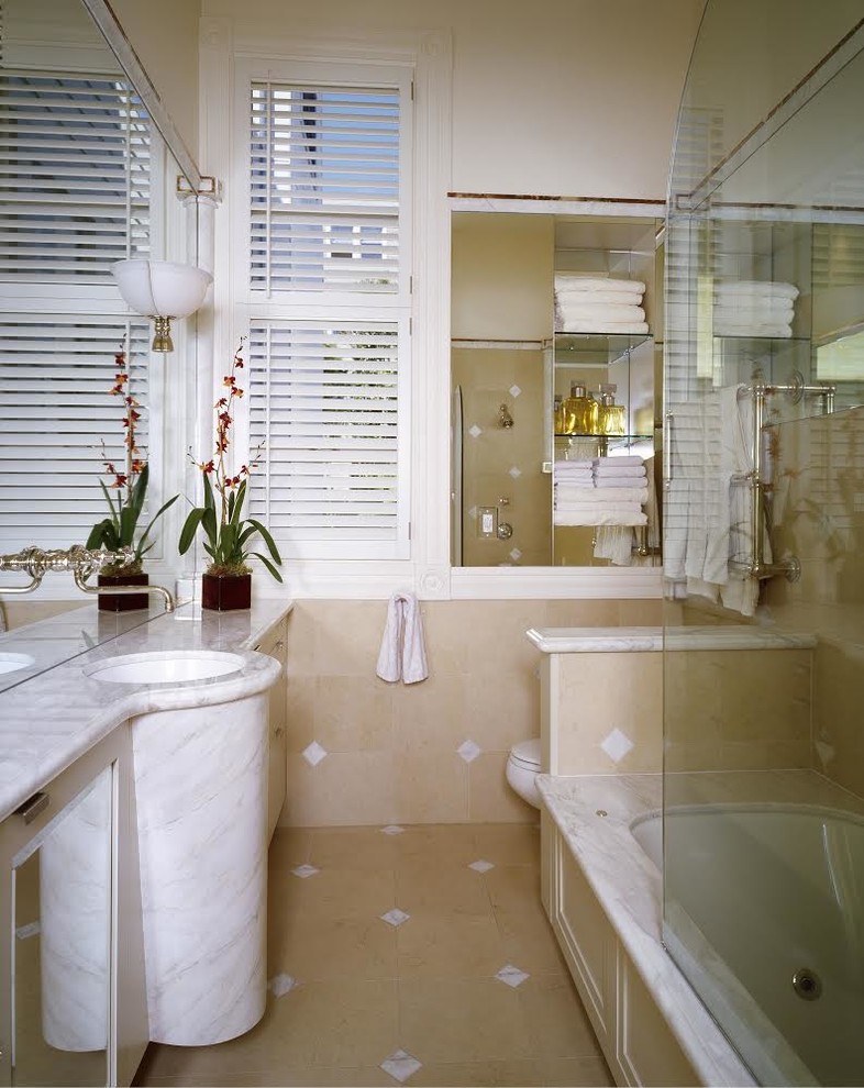 Ejemplo de cuarto de baño largo y estrecho tradicional con encimera de mármol y bañera encastrada sin remate
