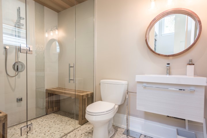 Medium sized classic ensuite bathroom in Toronto with beaded cabinets, white cabinets, beige tiles, grey tiles, white tiles, mosaic tiles, beige walls, a submerged sink, engineered stone worktops, a hinged door, a built-in shower, a two-piece toilet, pebble tile flooring and multi-coloured floors.