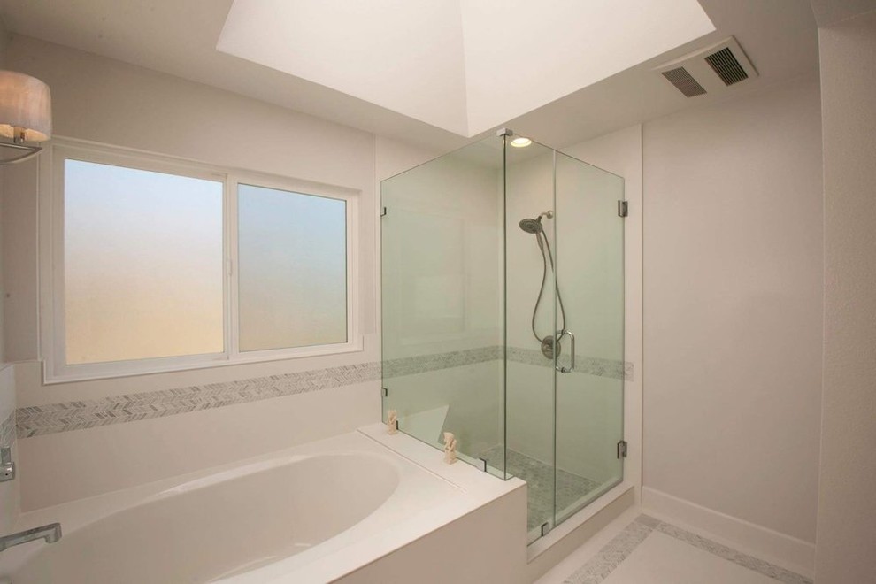 This is an example of a large traditional ensuite bathroom in Los Angeles with beaded cabinets, white cabinets, a built-in bath, a corner shower, a one-piece toilet, white tiles, ceramic tiles, grey walls, ceramic flooring, a built-in sink, marble worktops, white floors and a hinged door.