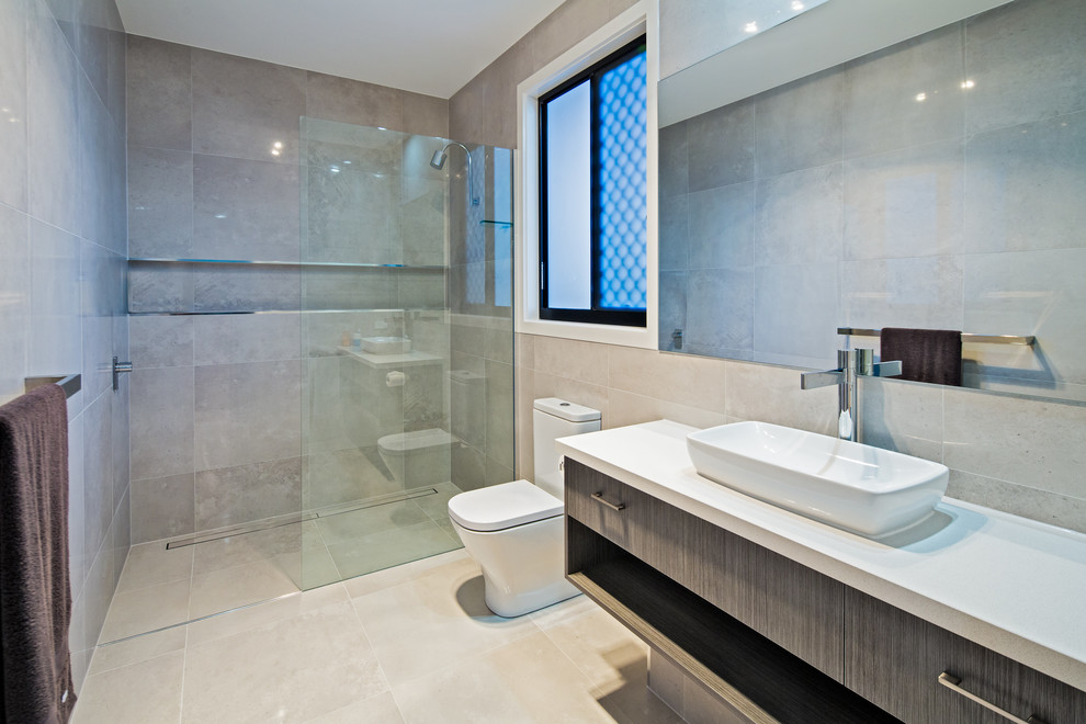 На фото: ванная комната в современном стиле с плоскими фасадами, темными деревянными фасадами, душем без бортиков, бежевой плиткой, бежевыми стенами, настольной раковиной и открытым душем с