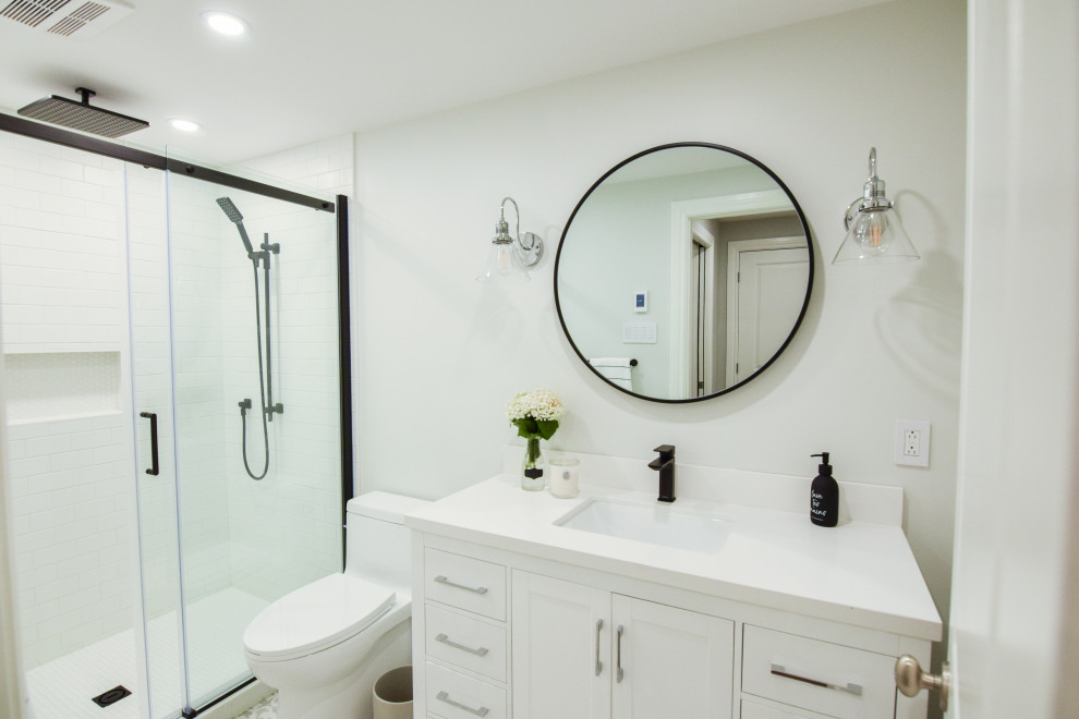 Idéer för att renovera ett litet lantligt vit vitt badrum med dusch, med skåp i shakerstil, vita skåp, en dusch i en alkov, en toalettstol med hel cisternkåpa, vit kakel, keramikplattor, blå väggar, klinkergolv i keramik, ett undermonterad handfat, bänkskiva i kvartsit, grått golv och dusch med skjutdörr