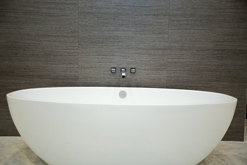 Inspiration för ett mellanstort funkis en-suite badrum, med släta luckor, vita skåp, ett fristående badkar, vita väggar, marmorgolv och ett undermonterad handfat