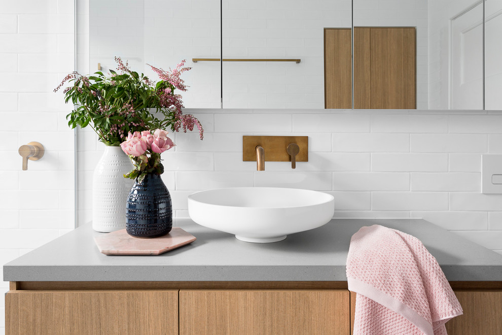 Inspiration for a large contemporary ensuite bathroom in Melbourne with flat-panel cabinets, medium wood cabinets, a freestanding bath, a walk-in shower, a two-piece toilet, grey tiles, white tiles, metro tiles, grey walls, ceramic flooring, a vessel sink, concrete worktops, blue floors, an open shower and grey worktops.