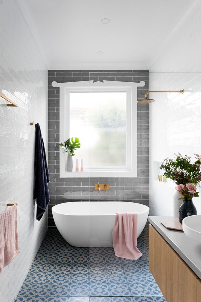 Inspiration pour une grande salle de bain principale design en bois brun avec un placard à porte plane, une baignoire indépendante, une douche ouverte, un carrelage gris, un carrelage blanc, un carrelage métro, une vasque, aucune cabine, WC séparés, un mur gris, un sol en carrelage de céramique, un plan de toilette en béton, un sol bleu et un plan de toilette gris.