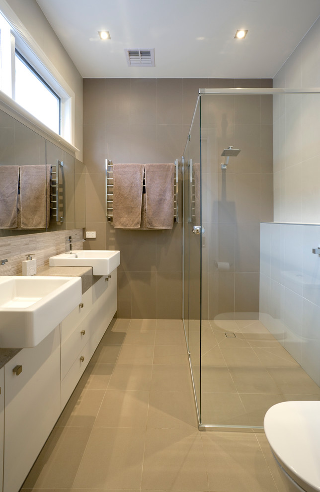 Idéer för mellanstora funkis en-suite badrum, med släta luckor, vita skåp, beige kakel och bänkskiva i kvarts