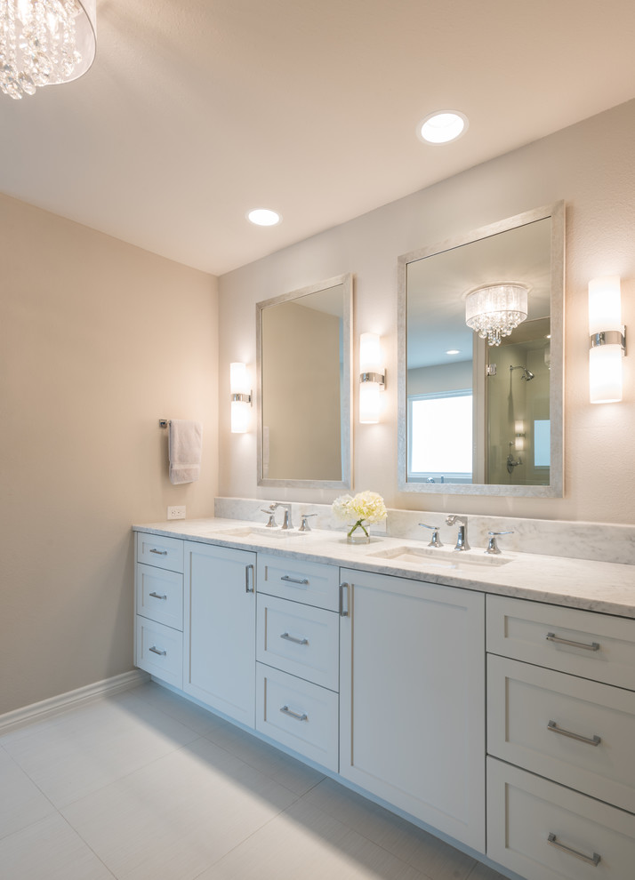 Photo of a medium sized classic ensuite bathroom in Dallas with shaker cabinets, beige cabinets, a freestanding bath, an alcove shower, a one-piece toilet, beige tiles, porcelain tiles, beige walls, porcelain flooring, a submerged sink and marble worktops.