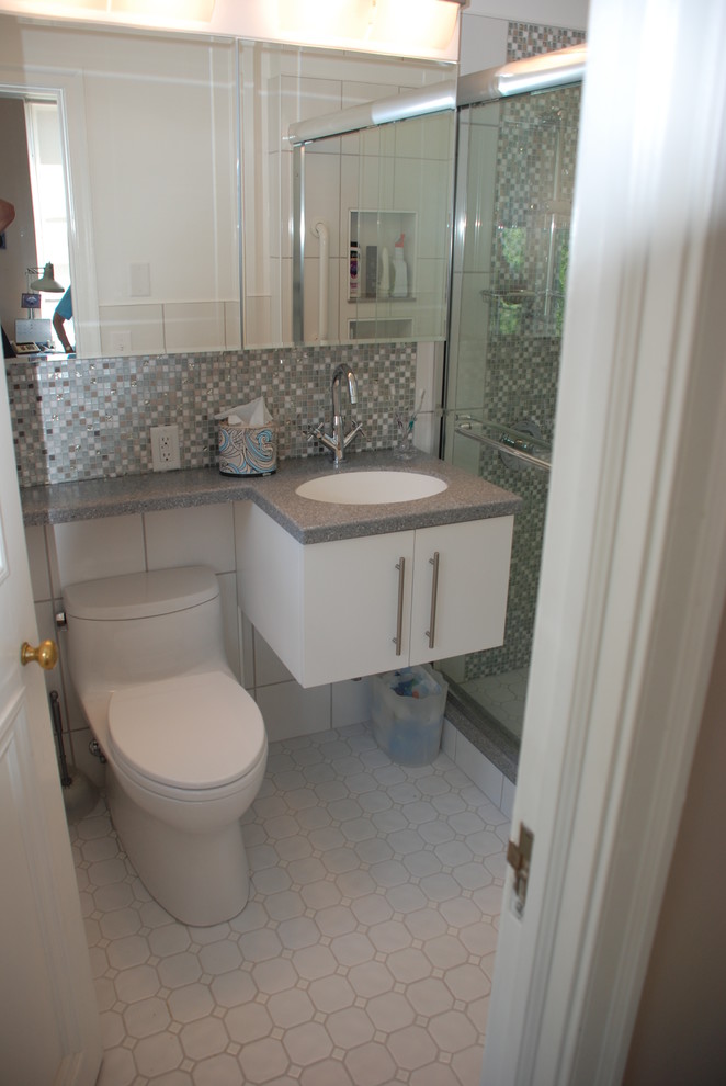 Photo of a small modern shower room bathroom in Richmond with a submerged sink, flat-panel cabinets, white cabinets, solid surface worktops, an alcove shower, a one-piece toilet, white tiles, ceramic tiles, grey walls and ceramic flooring.