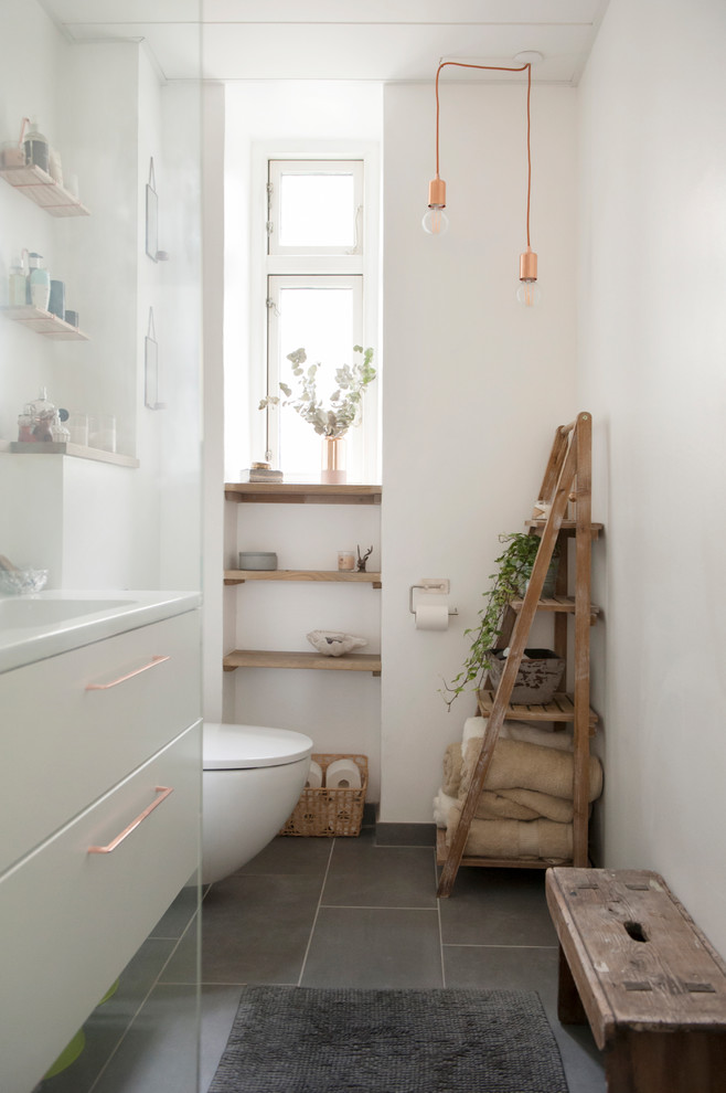 Пример оригинального дизайна: главная ванная комната в скандинавском стиле с плоскими фасадами, белыми фасадами, белыми стенами, серым полом, инсталляцией и консольной раковиной