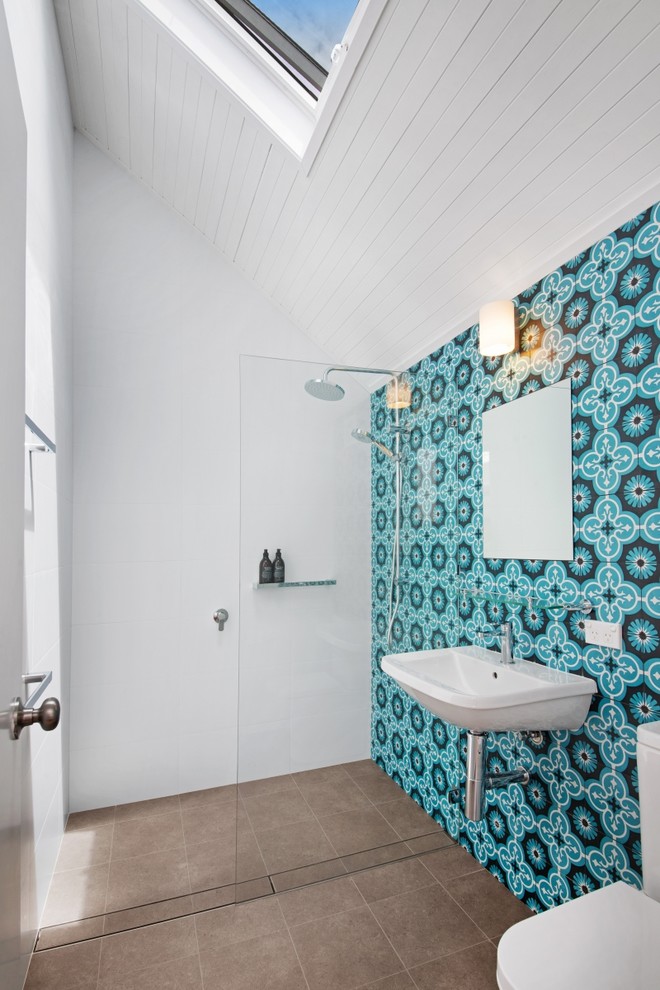 Пример оригинального дизайна: главная ванная комната среднего размера в современном стиле с душем без бортиков, унитазом-моноблоком, синей плиткой, керамической плиткой, синими стенами, полом из керамической плитки, подвесной раковиной, бежевым полом и открытым душем