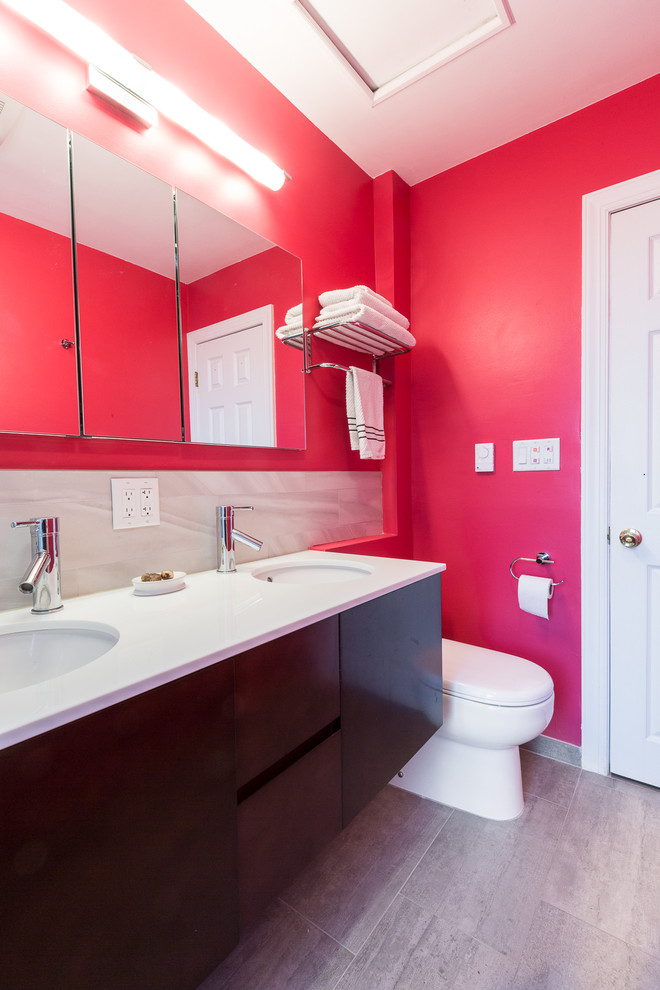 Inspiration pour une salle de bain principale design en bois foncé de taille moyenne avec un lavabo encastré, un mur rose, un placard à porte plane, une baignoire en alcôve, un combiné douche/baignoire, WC suspendus, un carrelage gris et un plan de toilette en quartz modifié.