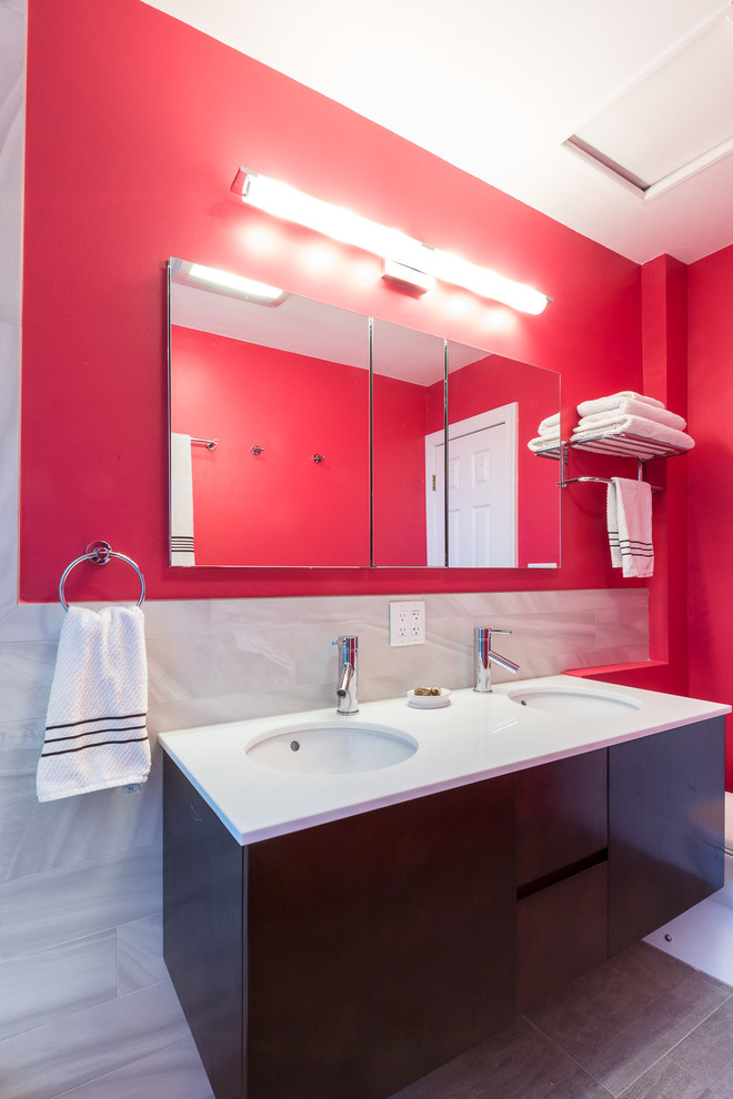 Idée de décoration pour une salle de bain principale design en bois foncé de taille moyenne avec un lavabo encastré, un mur rose, un placard à porte plane, une baignoire en alcôve, un combiné douche/baignoire, WC suspendus, un carrelage gris et un plan de toilette en quartz modifié.