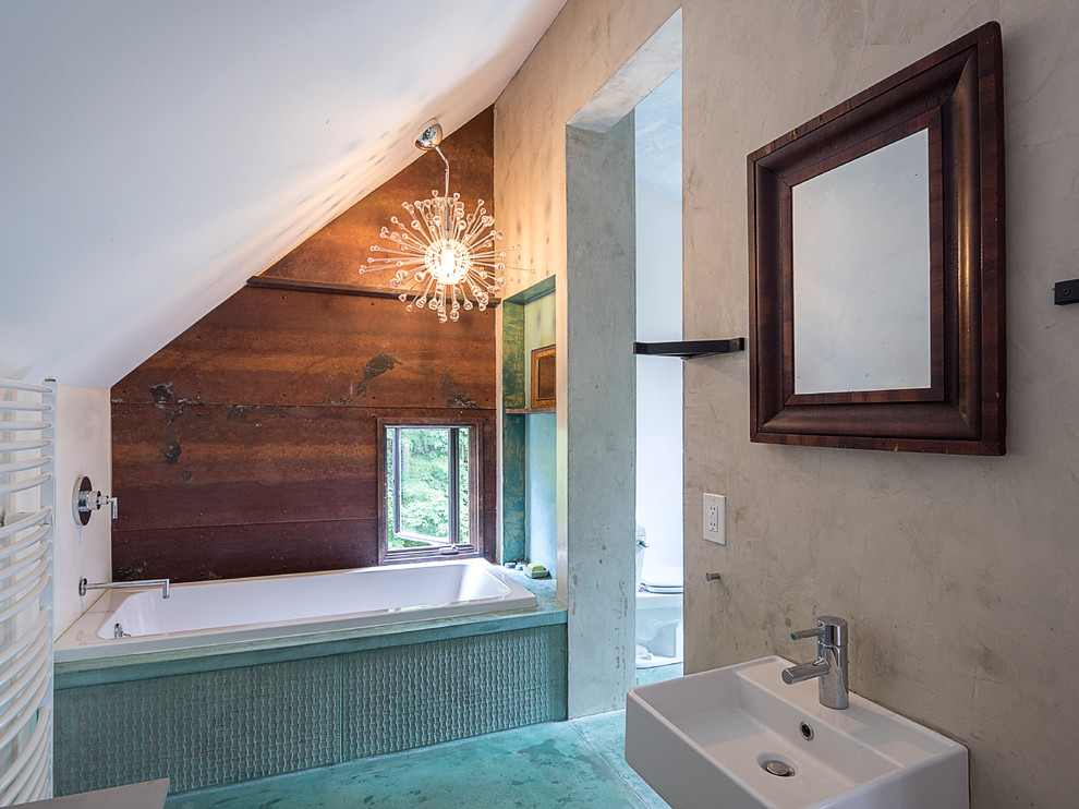 Aménagement d'une salle de bain principale contemporaine de taille moyenne avec une baignoire en alcôve, un carrelage marron, un mur gris, sol en béton ciré, un lavabo suspendu et un sol bleu.