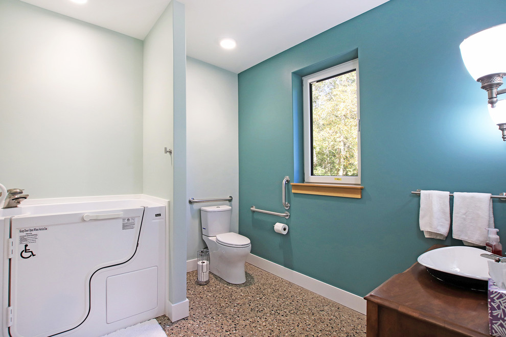 Example of a large 1960s master concrete floor and gray floor bathroom design in Grand Rapids with furniture-like cabinets, dark wood cabinets, a hot tub, a two-piece toilet, green walls, a vessel sink, wood countertops and brown countertops