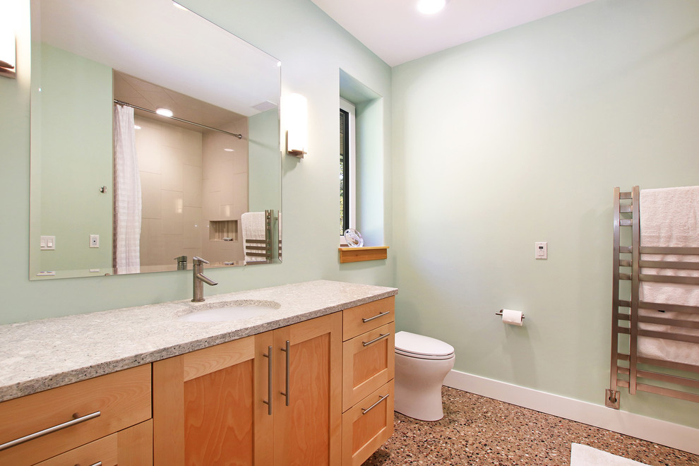 Example of a large mid-century modern master beige tile and ceramic tile concrete floor and gray floor bathroom design in Grand Rapids with recessed-panel cabinets, light wood cabinets, a two-piece toilet, green walls, an undermount sink, quartz countertops and gray countertops