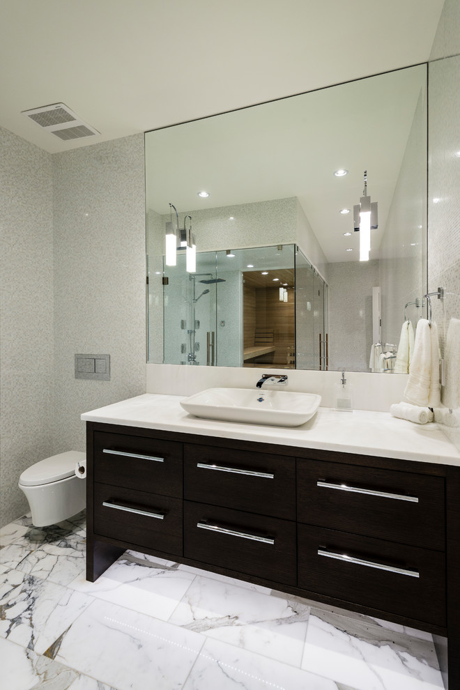 Bathroom - large contemporary multicolored tile and porcelain tile marble floor and white floor bathroom idea in Vancouver with flat-panel cabinets, dark wood cabinets, a wall-mount toilet, multicolored walls, a vessel sink, quartz countertops and a hinged shower door