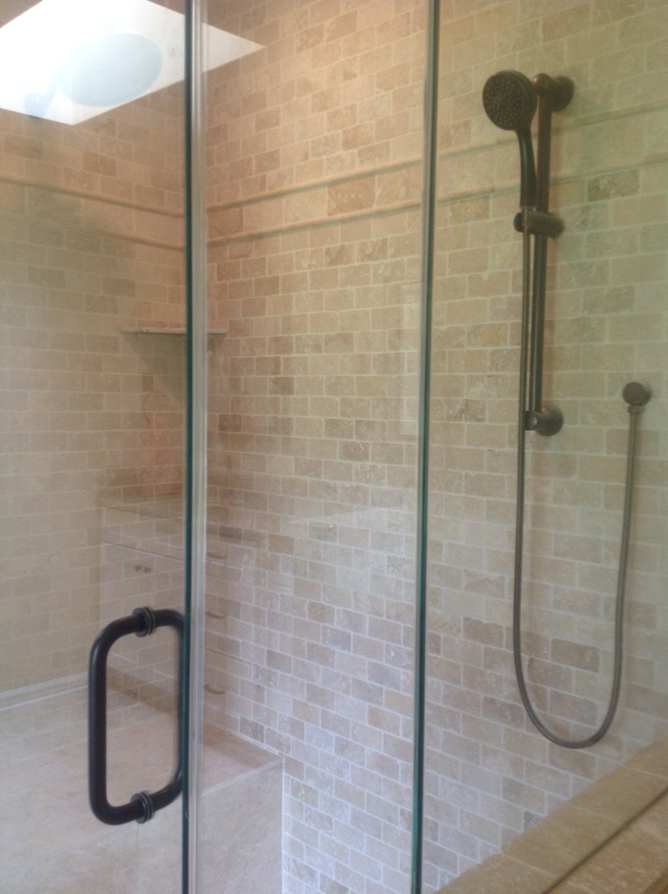Immagine di una stanza da bagno chic con ante con bugna sagomata, ante bianche, pareti beige, pavimento in travertino, lavabo sottopiano e top in granito