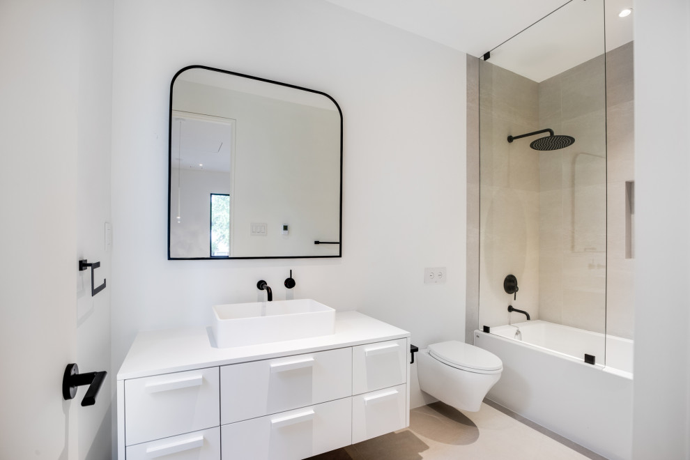 Example of a mid-sized transitional 3/4 white tile and porcelain tile double-sink freestanding bathtub design in Toronto with flat-panel cabinets, white cabinets, a wall-mount toilet, white walls, an integrated sink, tile countertops, a hinged shower door, white countertops and a built-in vanity
