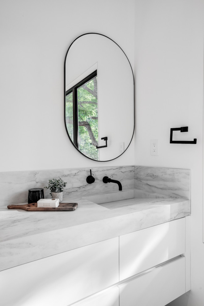 Inspiration for a medium sized contemporary ensuite bathroom in Toronto with flat-panel cabinets, white cabinets, white walls, an integrated sink, white worktops, double sinks and a floating vanity unit.