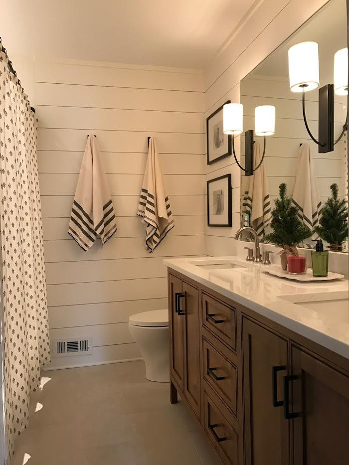 Aménagement d'une salle de bain en bois foncé de taille moyenne avec un mur blanc, un sol gris, meuble double vasque, meuble-lavabo encastré et du lambris de bois.