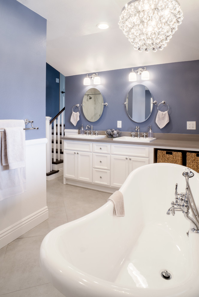 Идея дизайна: главная ванная комната среднего размера в стиле неоклассика (современная классика) с накладной раковиной, фасадами в стиле шейкер, белыми фасадами, столешницей из искусственного кварца, отдельно стоящей ванной, душем без бортиков, унитазом-моноблоком, белой плиткой, керамогранитной плиткой, синими стенами и полом из керамогранита