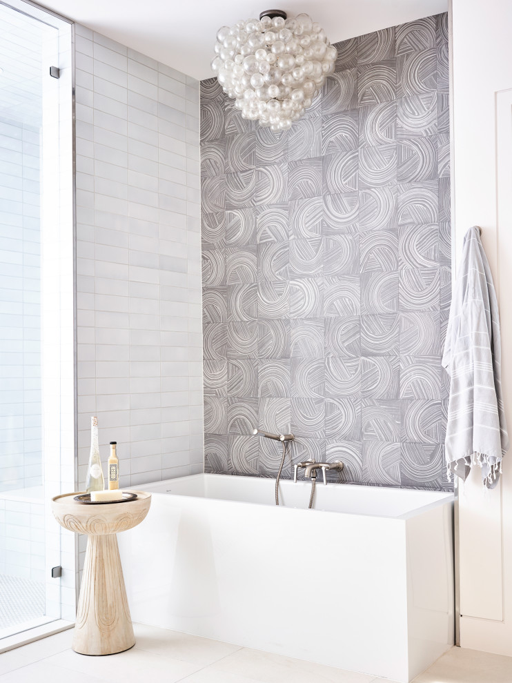 На фото: ванная комната в современном стиле с отдельно стоящей ванной, серой плиткой, белыми стенами и серым полом