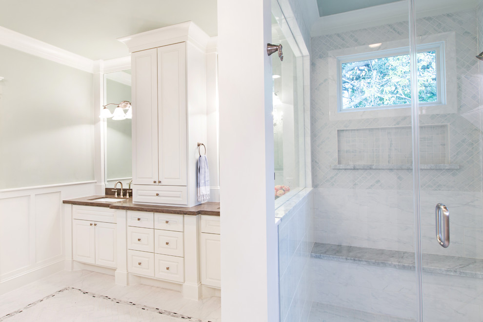 Huge elegant master white tile and porcelain tile marble floor bathroom photo in Denver with an undermount sink, raised-panel cabinets, white cabinets, limestone countertops, a two-piece toilet and green walls
