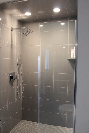 Inspiration for a medium sized modern ensuite bathroom in Philadelphia with recessed-panel cabinets, light wood cabinets, an alcove bath, a shower/bath combination, a two-piece toilet, white tiles, metro tiles, beige walls, marble flooring, a pedestal sink, marble worktops, white floors and a sliding door.