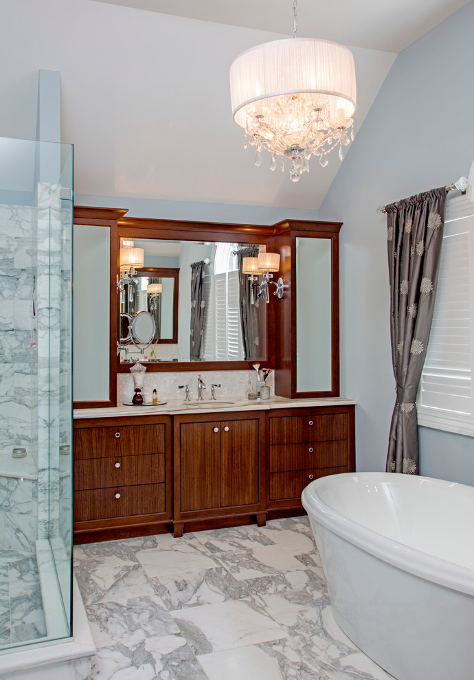 Cette image montre une grande salle de bain principale traditionnelle en bois foncé avec un lavabo encastré, un placard en trompe-l'oeil, un plan de toilette en marbre, une baignoire indépendante, une douche d'angle, un mur bleu et un sol en marbre.