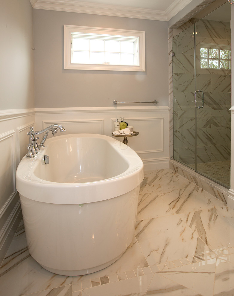 Immagine di una stanza da bagno design con vasca freestanding, pareti grigie, pavimento in marmo, doccia ad angolo, WC monopezzo, piastrelle in gres porcellanato e lavabo sottopiano