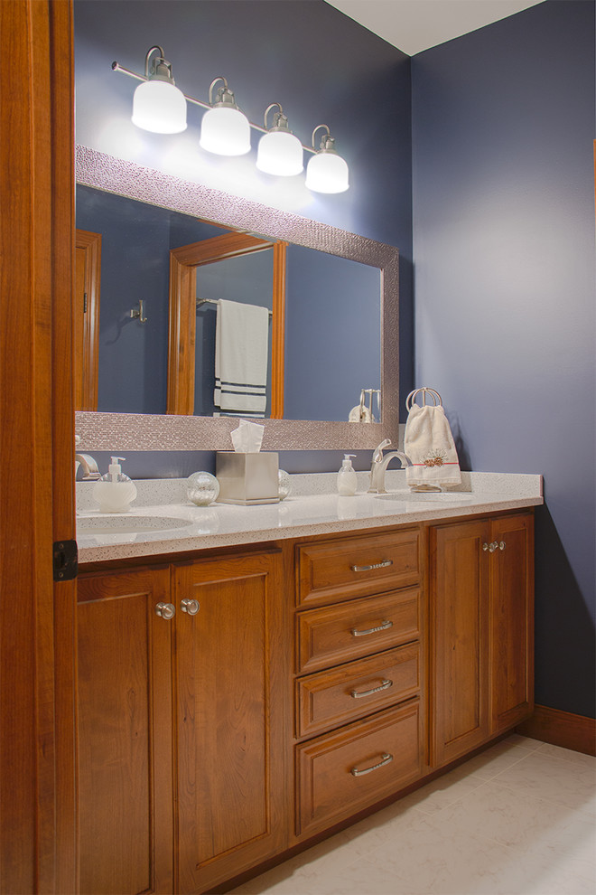 Esempio di una stanza da bagno padronale classica di medie dimensioni con ante con bugna sagomata, ante in legno scuro, top in quarzo composito e pareti blu