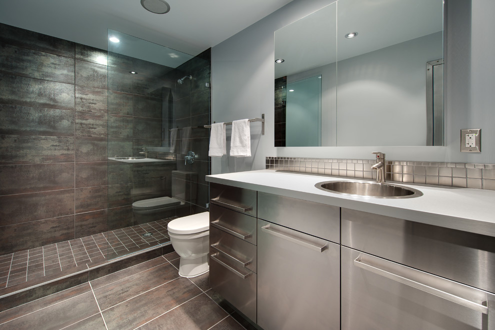 Réalisation d'une salle de bain design avec un plan de toilette gris.