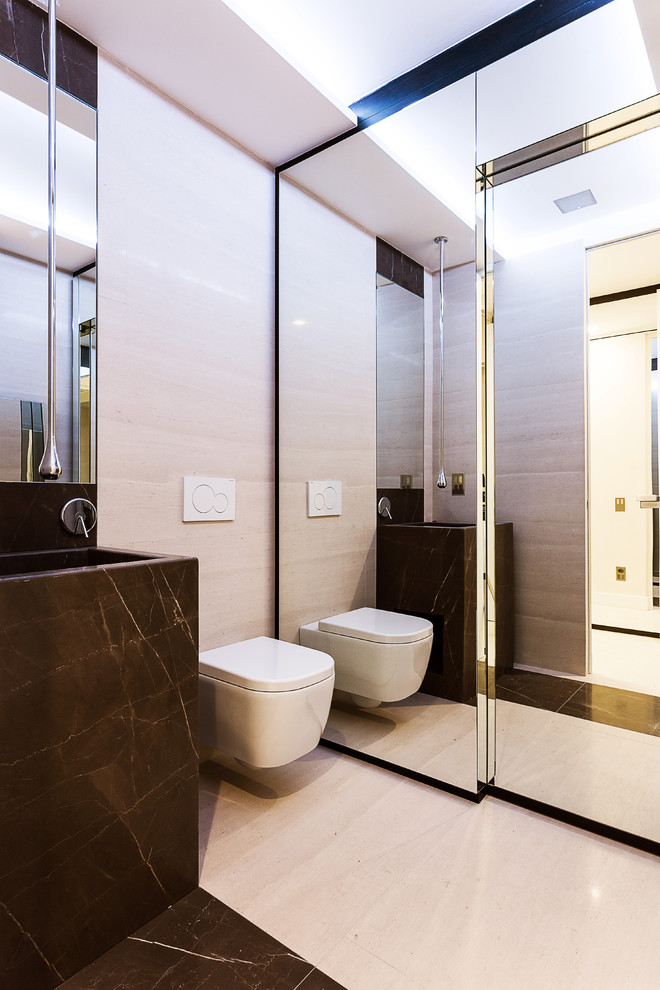 Modelo de cuarto de baño contemporáneo con sanitario de pared, baldosas y/o azulejos blancas y negros, losas de piedra, lavabo integrado y encimera de mármol