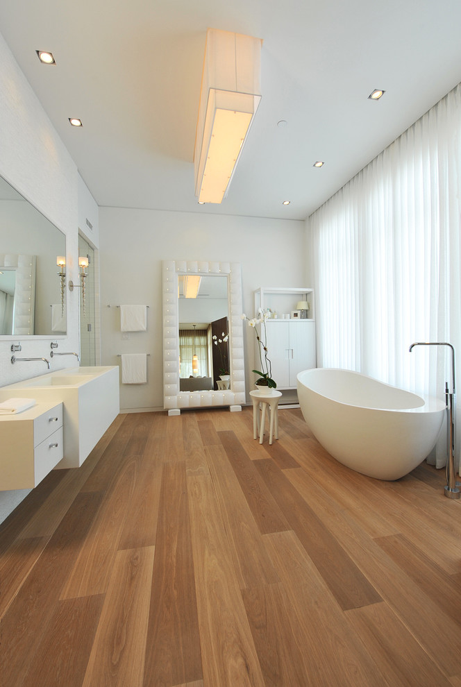 This is an example of a large contemporary ensuite bathroom in Miami with flat-panel cabinets, white cabinets, a freestanding bath, white walls and an integrated sink.