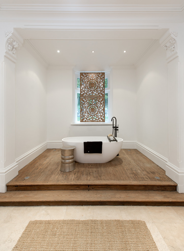 На фото: ванная комната среднего размера в средиземноморском стиле с отдельно стоящей ванной, паркетным полом среднего тона и коричневым полом с