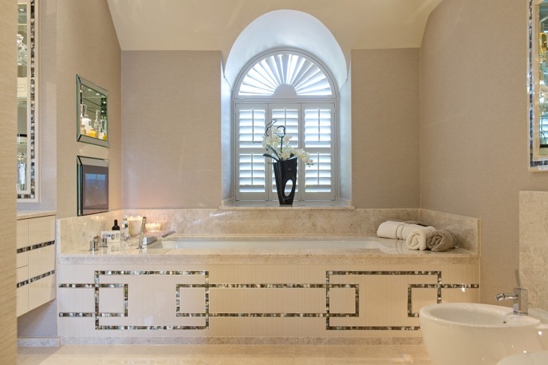 Modelo de cuarto de baño contemporáneo grande con bañera encastrada, ducha abierta, sanitario de pared, baldosas y/o azulejos beige, paredes beige, lavabo encastrado y encimera de mármol