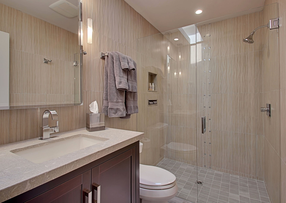 Example of a mid-sized transitional 3/4 gray tile and porcelain tile porcelain tile walk-in shower design in Other with an undermount sink, shaker cabinets, dark wood cabinets, limestone countertops, a two-piece toilet and gray walls