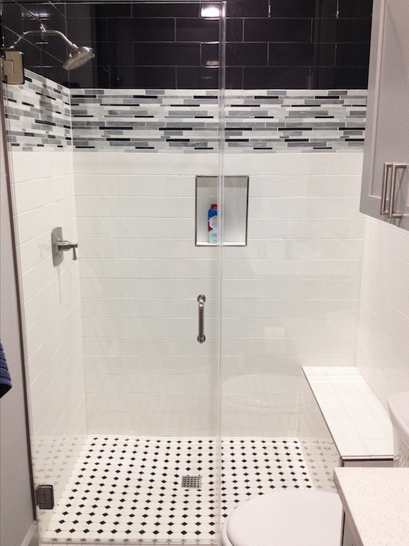 Idéer för ett litet modernt badrum, med ett fristående badkar, svart och vit kakel och mosaikgolv