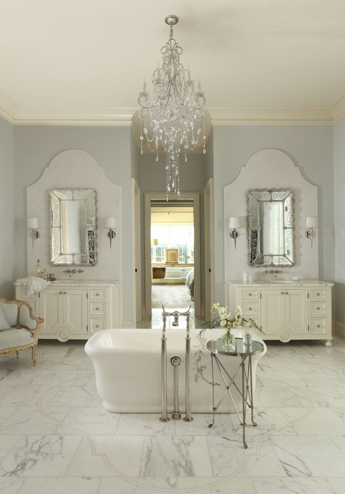 Exempel på ett klassiskt badrum, med ett undermonterad handfat, luckor med infälld panel, vita skåp, ett fristående badkar och vit kakel