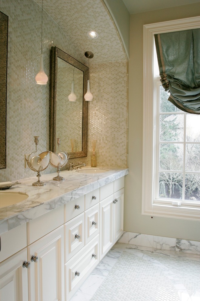 Idee per una stanza da bagno chic con lavabo sottopiano, ante con bugna sagomata, ante bianche, top in marmo, piastrelle beige e piastrelle in ceramica