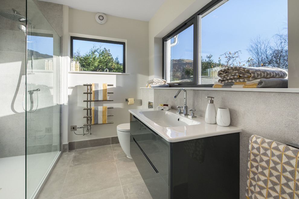 Пример оригинального дизайна: главная ванная комната среднего размера в современном стиле с серыми фасадами, открытым душем, унитазом-моноблоком, серой плиткой, серыми стенами, полом из керамогранита, накладной раковиной, серым полом и открытым душем