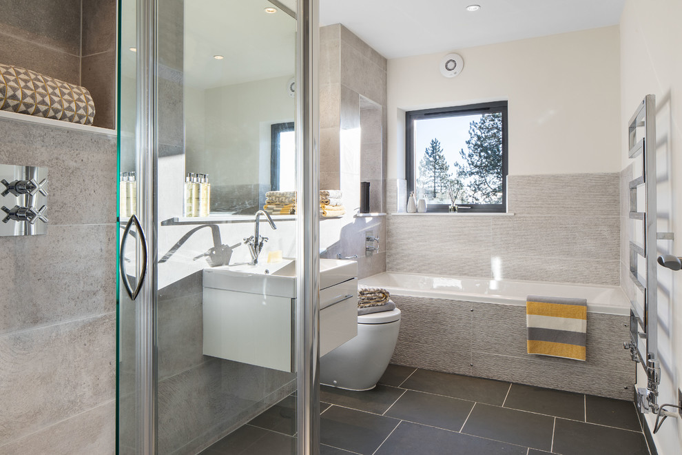 Photo of a medium sized contemporary family bathroom in Other with white cabinets, a built-in bath, a built-in shower, a one-piece toilet, grey tiles, grey walls, porcelain flooring, a built-in sink, grey floors and a hinged door.