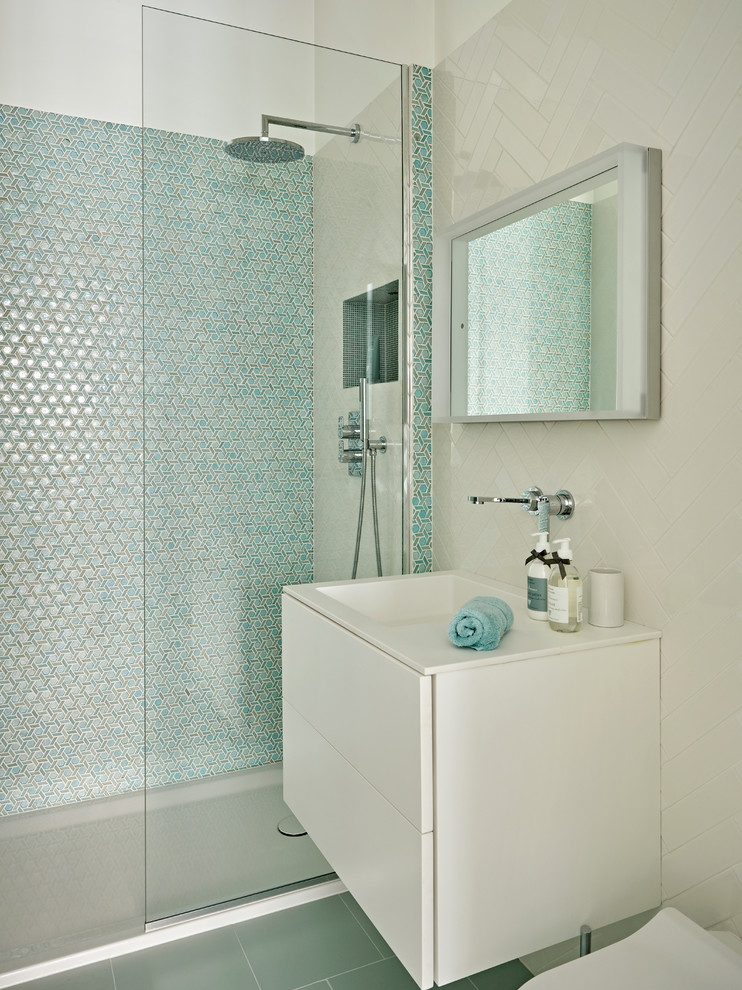 This is an example of a medium sized contemporary bathroom in London with flat-panel cabinets, white cabinets, a walk-in shower, blue tiles, white tiles, porcelain tiles, white walls, a wall-mounted sink, blue floors and an open shower.